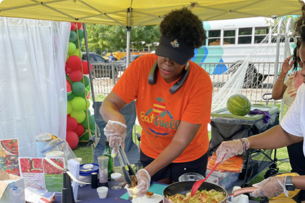 A community member preparing food at an outdoor event