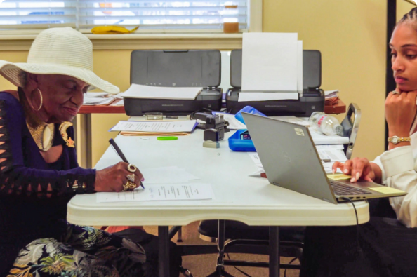 A resident and staff member completing paperwork together