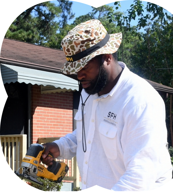 A community partner working on a home with a power tool