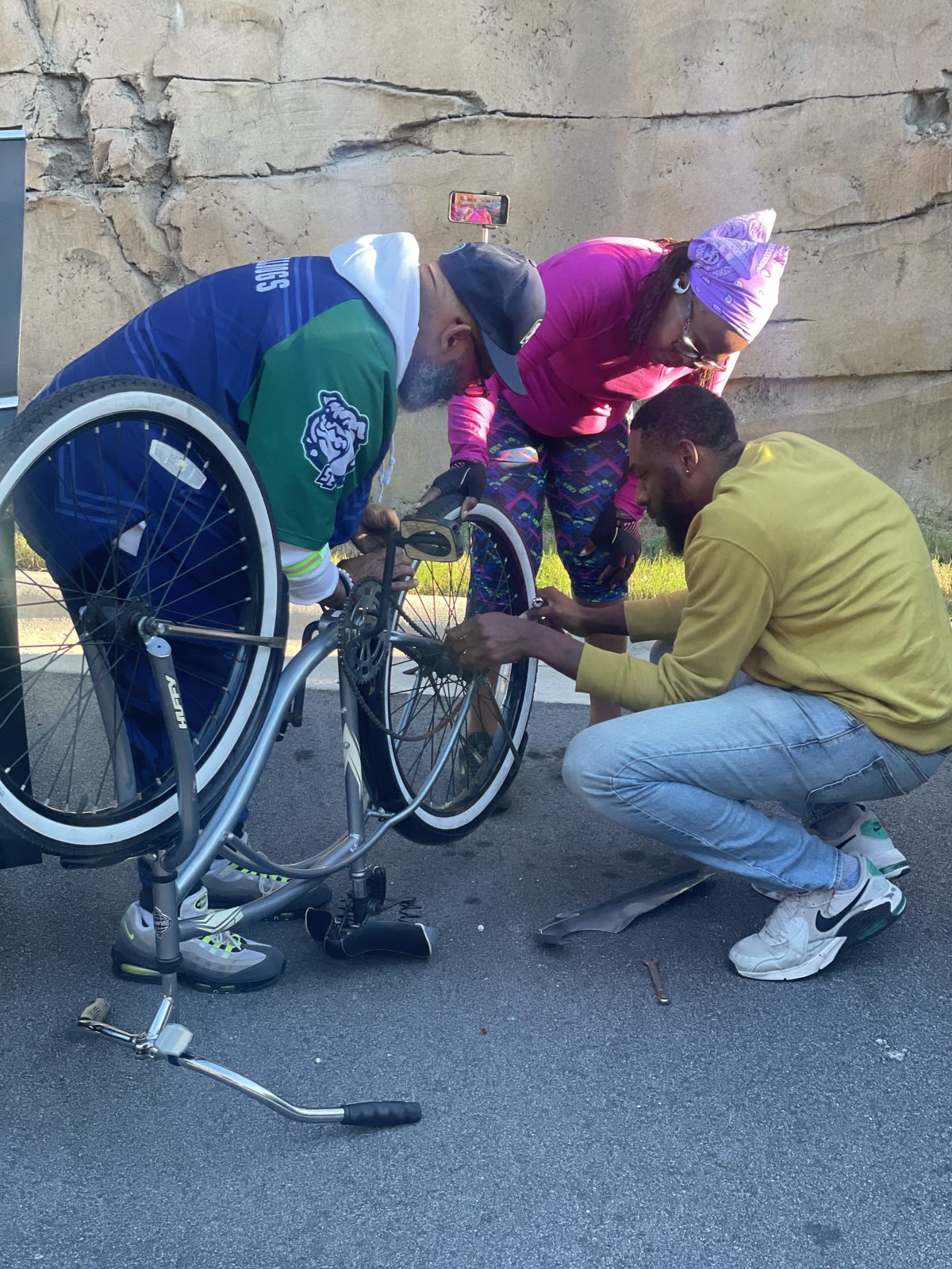 Two community members work together to repair a bike