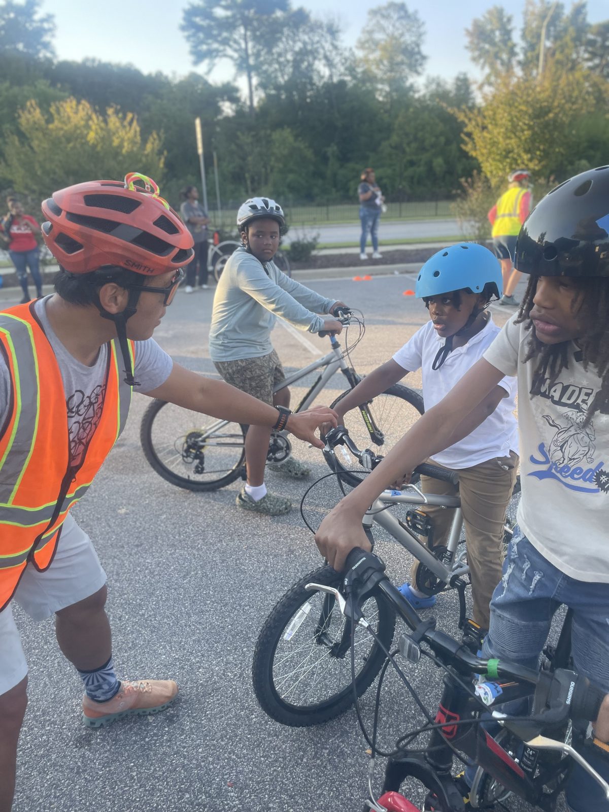 An instructor shows young riders how to use their hand brakes