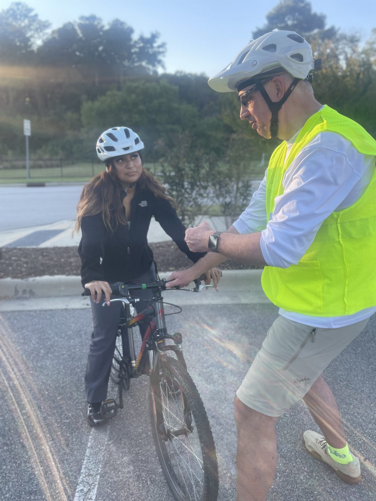A volunteer instructor helps a rider check her brakes and grip