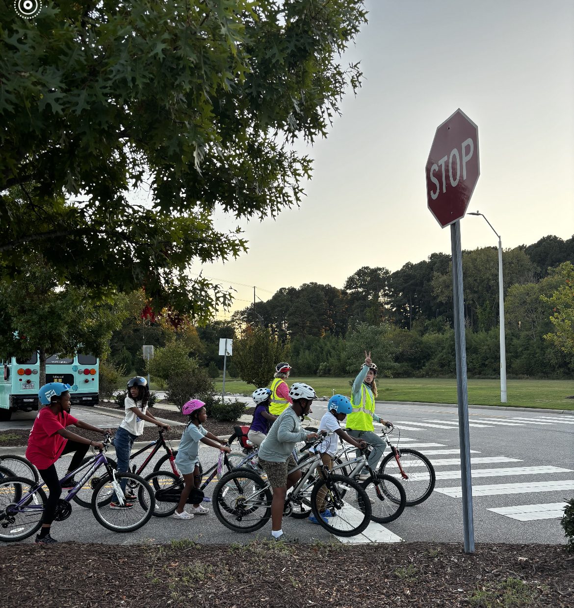 Young riders and instructors stop at a crosswalk during a practice ride