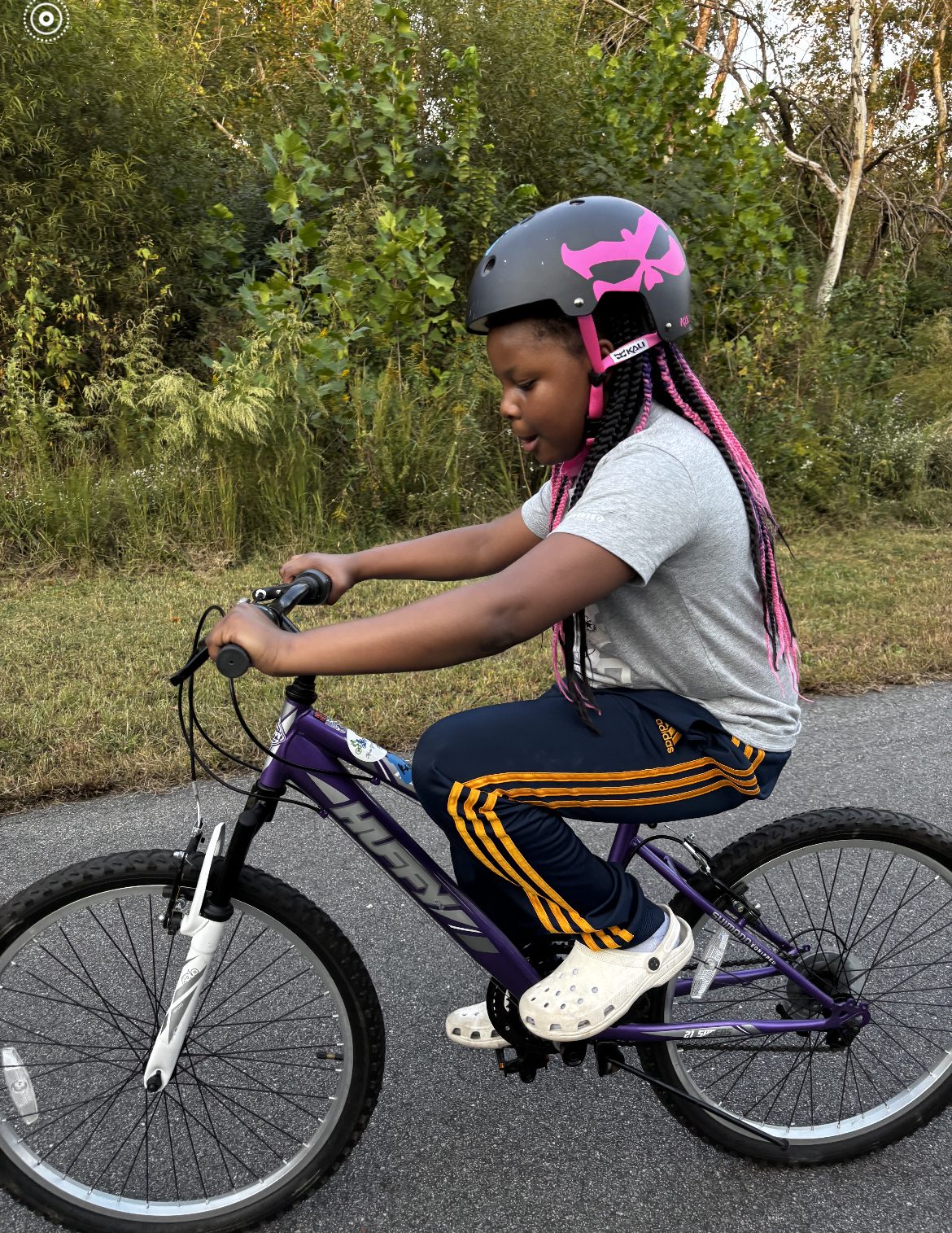 A young rider pedals along a greenway trail